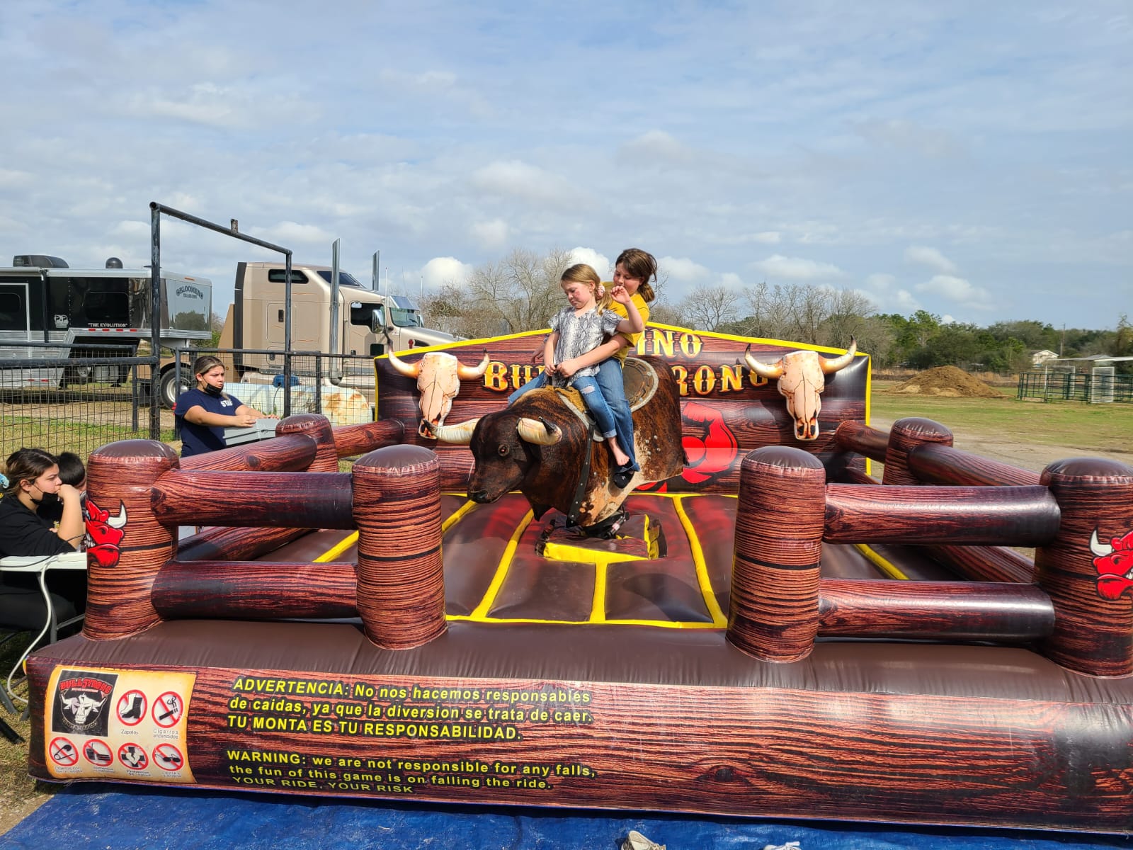 mechanical bull with two kids riding on top